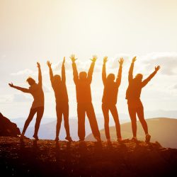 Five happy friends with raised arms